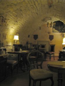 Sala w której są krzesła i stołu Ma klimat lochów. Jest to kawiarnia.