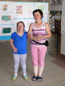 Kobiety stoją . Pozują do zdjecia. Uśmiechają się. Trzymają sie pod rękę.