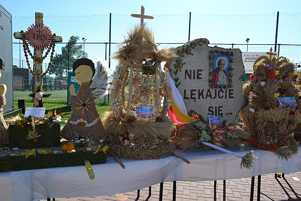 Jest pomnik nie lękajcie się. Wokół niego kwiaty. Jest słonecznie.