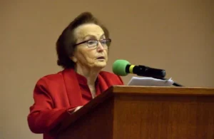 kobieta stoi przy mównicy. Obok mikrofon.