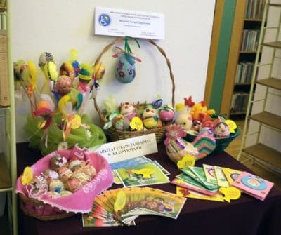 Na stoliku z czarnym obrusem koszyczki z kolorowymi pisankami oraz ręcznie przygotowane kartki świąteczne