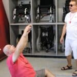 Zawodnik podrzucający piłkę w konkurencji piłka siatkowa na siedząco w III Dniu Pikniku