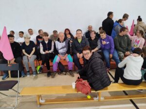 Grupa osób kibicująca sportowcom.