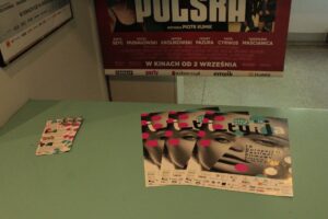 Plakaty i ulotki wydarzenia Integracja Ty i Ja rozłożone na zielonym blacie stołu.