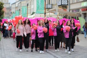 Młode uśmiechnięte kobiety z pomponami, z zespołu tanecznego „Fly Five” idące na czele Marszu.