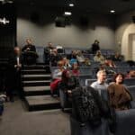 Dużo osób obydwu płci siedzących na widowni;