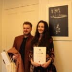Pani Katarzyna Kubiak stojąca przy wyróżnionej nagrodą Grand Prix fotografii własnego autorstwa, obok towarzyszący Jej mężczyzna
