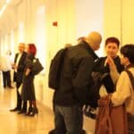 Kilka osób obu płci rozmawiających i oglądających w Wirydarzu Centrum Kultury w Lublinie, zwycięskie fotografie 13. Międzynarodowego Konkursu Fotograficznego „Teatr w Obiektywie”