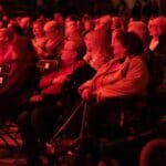 Siedząca w półmroku widownia – dużo ludzi obu płci