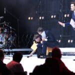 Trzy osoby na scenie, od lewej: schylająca się kobieta Pani Katarzyna Rzehak, siedzący na małym bujanym koniku Pan Kamil Kowalski (przedstawiciele Integracji, członkowie Jury konkursu na Dostępny plac zabaw „Inte-GRA”) oraz stojący Pan Tomasz Wolny