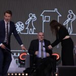 Cztery osoby na scenie: stojący Pan Tomasz Wolny, siedzący na fotelu Pan Paweł Wdówik – Pełnomocnik Rządu ds. Osób Niepełnosprawnych, podająca mu mikrofon stojąca kobieta oraz siedząca na fotelu Pani Anna Paruch