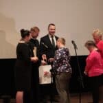 Pani Ewa Borkowska – Dyrektor Miejskiego Ośrodka Pomocy Społecznej w Białej Podlaskiej, ks. Paweł Zazuniak – Dyrektor Caritas Diecezji Siedleckiej i Pan Jakub Semeniuk – Kierownik Warsztatów Terapii Zajęciowej w Białej Podlaskiej podczas wręczania nagrody i składania gratulacji Dyrekcji i Uczestnikom WTZ Łuków za zajęcie II miejsca za film pt. „Cud”