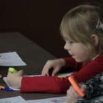 Dziewczynki rysujące przy stoliku w kąciku plastycznym