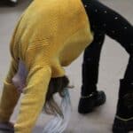 Dziewczynka wykonująca tzw. mostek, tj. ćwiczenie gimnastyczne, polegające na uniesieniu miednicy na wspartych nogach i rękach.