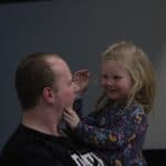 Mężczyzna z uśmiechniętą dziewczynką na ręku