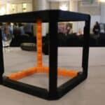 Rozłożona przestrzennie makieta dotykowa sześcianu w kolorze czarno-pomarańczowym, przystosowana do nauki geometrii osób z niepełnosprawnością wzroku, pochodząca z zasobów Centrum Aktywizacji Osób z Niepełnosprawnością KUL JP II