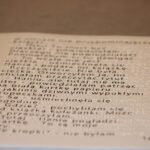 Biała stronica z książki autorstwa Pani Katarzyny Michailidis pt. “Hania i Mania”, napisana czarnym tekstem i alfabetem Braille'a