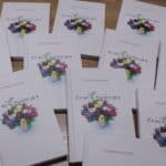 Kilkanaście egzemplarzy tomiku poezji autorstwa niewidomej poetki Zuzanny Ostafin pt. „Co mi w duszy gra”, ułożonych na stoliku stoiska kiermaszowego WTZ Caritas w Ropczycach