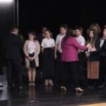 Na scenie Małgorzata Jarosińska-Jedynak (Sekretarz Stanu w Ministerstwie Funduszy i Polityki Regionalnej) gratulująca Antoniemu Karolowi Kamińskiemu (Dyrektorowi Szkoły Usług Hotelarskich, Sztuki Gotowania i Innych Zawodów w Dębicy, Prezes Fundacji „Educare et Servire”) stojącemu w towarzystwie młodzieży szkolnej