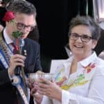 Marek Michalak (Kanclerz Kapituły Orderu Uśmiechu) podający uśmiechniętej Bożenie Kazanowskiej puchar z sokiem z cytryny