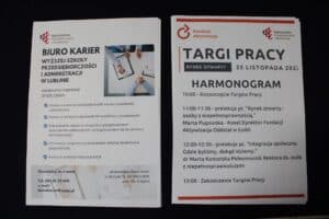 Leżące na stoisku plakaty informacyjne Biura Karier Wyższej Szkoły Przedsiębiorczości i Administracji oraz harmonogram Targów Pracy „Rynek Otwarty”