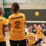 Plecy zawodniczek Instytutu Pedagogiki: z nr 3 dr Anna Grabowiec, z nr 2 dr Agnieszka Bochniarz, obserwujące rozgrywająca się w tle akcję na boisku