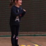 Radość małej dziewczynki uchwycona w momencie delikatnego podskoku; efektem czego unosi się ona lekko ponad podłożem