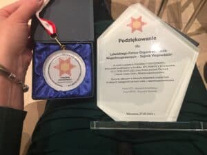 Pamiątkowy medal "strażnika dostępności" oraz statuetka z podziękowaniem dla LFOON za wzięcie udziału w projekcie