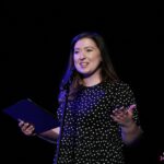 Stojąca na scenie przy mikrofonie prowadząca - Małgorzata Adamczyk