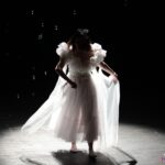 Scena przemiany w spektaklu pt. „Brzydkie Kaczątko”, w której tytułowe "kaczątko", zamieniło się w łabędzia, którego symbolizuje kobieta ubrana w piękną białą suknię