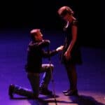 Scena w spektaklu pt. „Przebudzenie”: oświadczyny - mężczyzna klęczy przed kobietą, w ręku trzyma pudełeczko z pierścionkiem zaręczynowym