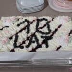 Tort okolicznościowy ozdobiony borówkami, ułożonymi w napis "10 lat"