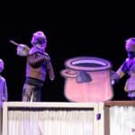 Trzy kukiełki i tekturowy garnek z kamieniem - scena w spektaklu pt. „Zupa z kamienia”