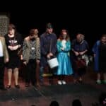 Stojący na scenie w przebraniach, aktorzy Teatru Cygańskie Promyki tuż po zakończeniu spektaklu pt. „W kawiarni Zegarynka”