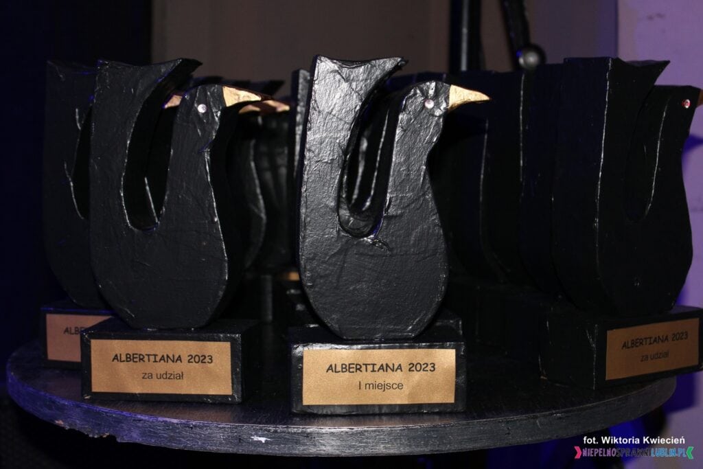 Ustawione na stoliku statuetki wręczane uczestnikom i laureatom II etapu regionalnego ALBERTIANA 2023