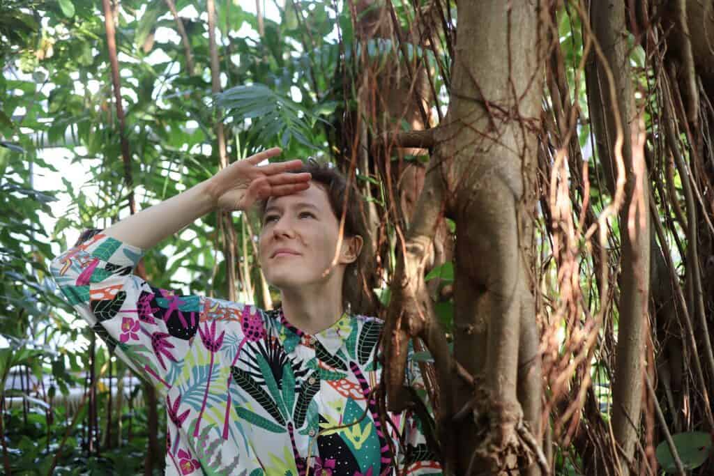 Stojąca przy drzewie, patrząca w dal kobieta w kolorowej bluzce - Ida Tymina, fot. Sabina Markowska, 2022