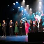 Na scenie stoją od lewej: prowadzący Galę Aleksandra Borzęcka oraz Maciej Cieciora, Pan dr Krzysztof Żuk - Prezydent Miasta Lublin, Pani Aleksandra Kulik - Prezes Zarządu Fundacji Sempre a Frente, Pan Kamil Konieczny - Przewodniczący Młodzieżowej Rady Miasta Lublin, Pani Agnieszka Parol-Górna - Koordynator Europejskiej Stolicy Młodzieży, Pani Beata Stepaniuk-Kuśmierzak - Zastępca Prezydenta Miasta Lublin ds. Kultury, Sportu i Partycypacji, Pełnomocnik Prezydenta Miasta Lublin ds. Europejskiej Stolicy Młodzieży oraz reprezentanci miasta Tirana: Irena Topalli i Bledar Iljazi