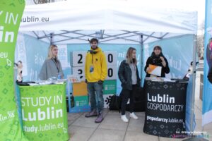 4 osoby na stoisku wystawienniczym Urzędu Miasta Lublin podczas wydarzenia "Studiuj w Lublinie - Europejskiej Stolicy Młodzieży 2023"