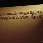 Wypukły napis na ścianie w języku polskim i angielskim „Magia Starożytnego Egiptu. The Magic of Ancient Egypt”