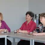 Trzy uczestniczki spotkania siedzące przy stole