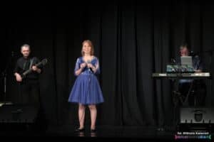 Koncert Pani Agnieszki Zarzyckiej; na scenie stoją od lewej: Pan Andrzej Bielecki, Pani Agnieszka Zarzycka, Pan Marek Kowal