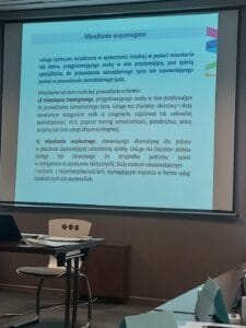 Ekran multimedialny z wyświetlonym slajdem pt. "Mieszkanie wspomagane"