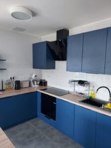 Pomieszczenie kuchenne z zabudową w kolorze ciemnoniebieskim