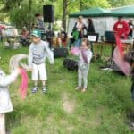 Trójka dzieci w wieku przedszkolnym bawi się kolorowymi chusteczkami w opiekunką