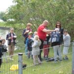 Dzieci w wieku przedszkolnym w towarzystwie opiekunów, oczekują na możliwość wypłynięcia w rejs