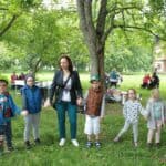 Grupa dzieci w wieku przedszkolnym wraz z opiekunem podczas zabawy w plenerze