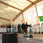 Na scenie Zespół Tańca Ludowego “Leszczyniacy” ze Świdnika, tancerze ubrani w stroje biłgorajskie, kapela w stroje świdnickie