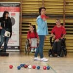 Sędzia wskazuje kolejność rzutów osobie rzucającej czerwonymi bilami