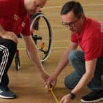 Sędziowie na boisku dokonują pomiarów odległości pomiędzy bilami