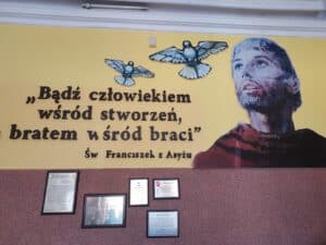 Ściana ozdobiona myślą św. Franciszka z Asyżu: "Bądź człowiekiem wśród stworzeń, a bratem wśród braci"